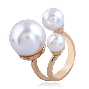 Detail of adjustable gold ring featuring three white pearls in a linear arrangement