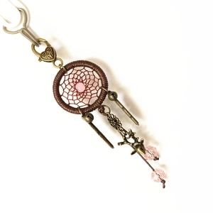 Close-up of brown dreamcatcher keychain with pink beads and bronze deer charm