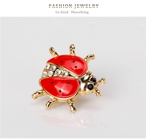 Detailed view of ladybug brooch featuring red enamel wings and sparkling rhinestones