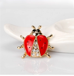 Detailed view of ladybug brooch with red enamel wings and sparkling rhinestones