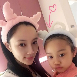 Matching plush reindeer antler headbands worn by a woman and child in pink and white