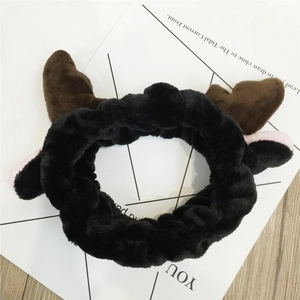 Detail of plush cow theme headband with brown horns and soft ears for makeup