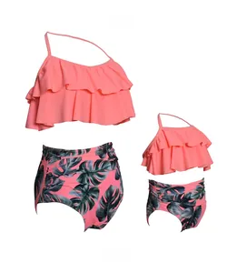Close-up of pink tiered ruffle bikini top and high waist tropical leaf print bottom