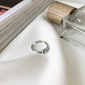 Minimalist S925 sterling silver double-line knot open ring on white textured fabric
