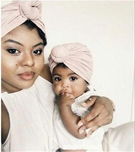 Pink cotton turban hats for parent and child in a cozy home setting with knotted design
