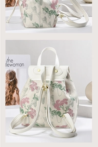 Detail of floral embroidery on a white leather mini backpack with gold hardware