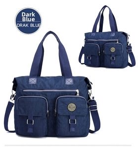 Detail view of large dark blue waterproof nylon travel bag with functional front pockets