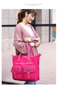Close-up of waterproof rose red nylon tote bag featuring multi-pocket design and metallic zippers