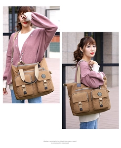 Detail of khaki water-resistant travel tote showing multiple zip pockets and adjustable straps