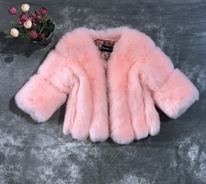 Dettaglio della giacca rosa in finta pelliccia con consistenza peluche e maniche a tre quarti