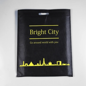 Detalle de bolsa negra de tela no tejida con texto Bright City y silueta de ciudad