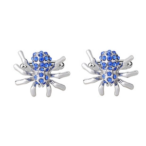 Detailed view of silver spider cufflinks with blue rhinestones on a white background