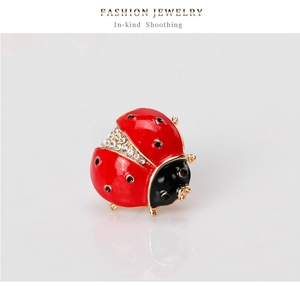 Macro view of insect ladybug brooch with red enamel finish and sparkling rhinestones