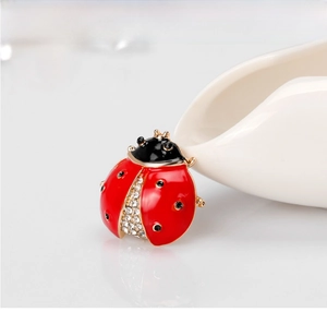 Macro shot of a red ladybug brooch with crystals and gold-plated alloy details
