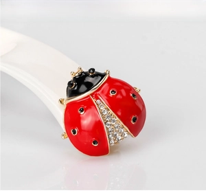 Detailed view of ladybug brooch with red enamel and sparkling crystal inlay