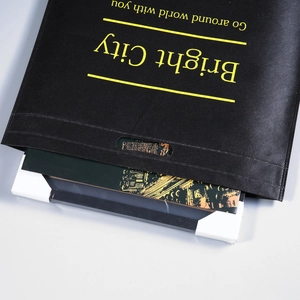 Detalle de la bolsa grande de tela no tejida negra con texto artístico amarillo