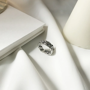 Retro vintage 925 silver woven open ring with adjustable band on white fabric background