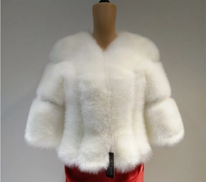 Dettaglio della trama di un cappotto bianco in ecopelliccia con fibre spesse e maniche a tre quarti
