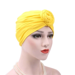 Detail of yellow turban hat with elegant 3D rose knot on soft cotton fabric