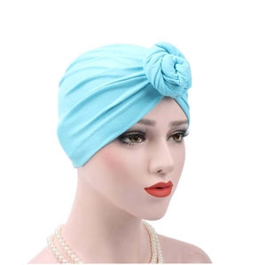 Close-up of light blue pleated turban hat with front knot detail on a mannequin