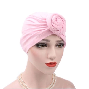 Detailed close-up of a pink cotton turban hat featuring a decorative rose flower knot