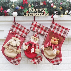Three festive Christmas stockings with Santa, Snowman and Reindeer on a fireplace mantel