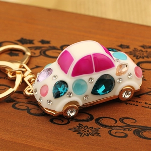 Macro detail of a golden car keychain pendant inlaid with colorful crystal rhinestones