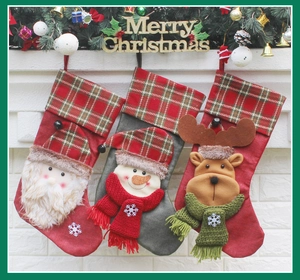 Detailed view of three plush Christmas stockings with Santa, Snowman and Reindeer motifs
