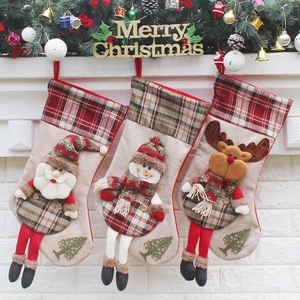 Three festive Christmas stockings with Santa, Snowman and Reindeer hanging on a fireplace