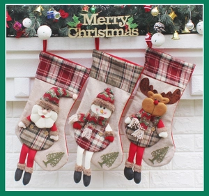 Close-up of three Christmas stockings with Santa, Snowman, and Reindeer hanging on fireplace