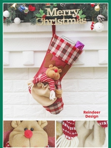 Detail of red Christmas stocking with 3D reindeer plush doll and plaid cuff patterns