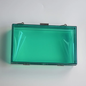 Detail view of transparent green acrylic evening clutch with silver metal hardware and frame