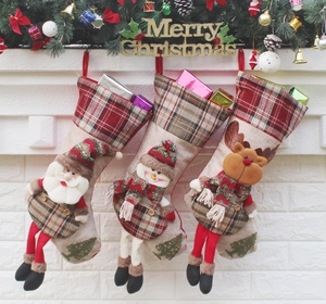 Detailed close-up of three festive linen Christmas stockings hanging on a fireplace