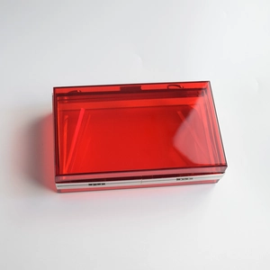 Detailed close-up of translucent red acrylic clutch bag with elegant silver metal frame