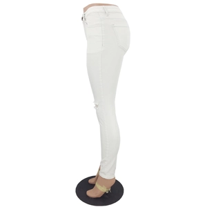 Detail of white slim fit distressed jeans showing the knee ripped hole craftsmanship