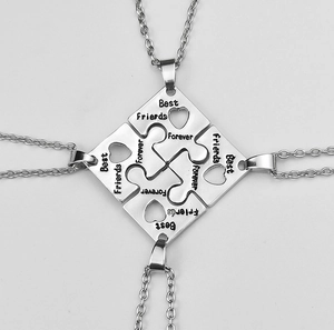 Detail of four stainless steel puzzle heart necklaces with Best Friends Forever engraving