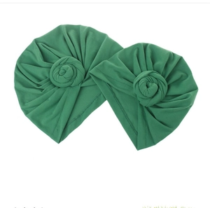 Detail of green baby turban set featuring soft elastic fabric and donut knot design