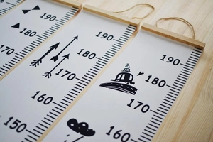 Detail of wooden canvas growth charts showing precise measurements and cartoon patterns