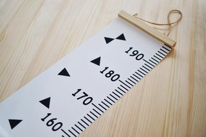 Detail of wooden hanger and canvas texture on a minimalist Nordic style height growth chart