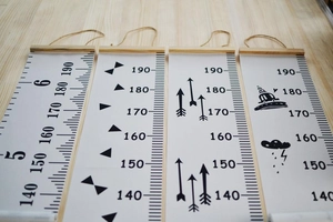 Detail view of canvas growth charts with wood hangers and measurements up to 190cm