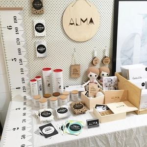 Detail of wooden growth chart and milestone cards displayed on a minimalist pegboard