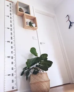 Detail of hanging wooden growth chart with dual cm and feet scales for kids room