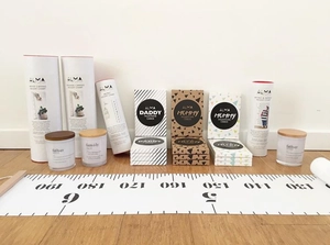 Detail view of canvas height chart milestone cards and scented candle gift set on wood