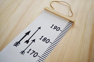 Detail of wooden hanging bar and jute rope on Nordic style canvas growth chart