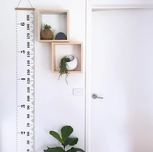 Close-up of Nordic style canvas height chart with wooden frame on white wall background