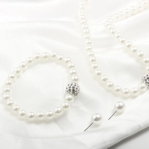 Détail de parure de bijoux en perles blanches avec perles disco en cristal étincelant