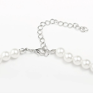Détail macro du collier de perles blanches avec fermoir mousqueton et chaîne d'extension