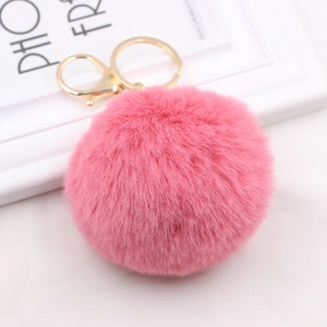 Detail of pink fluffy faux rabbit fur keychain with a gold metal lobster clasp