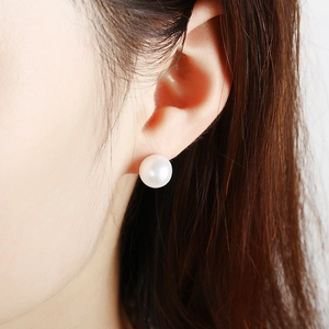 Vue latérale macro de boucles d'oreilles en perles blanches au fini élégant