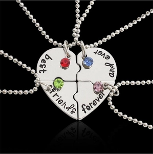 Detailed macro shot of four-piece heart puzzle necklaces with colorful crystals for best friends